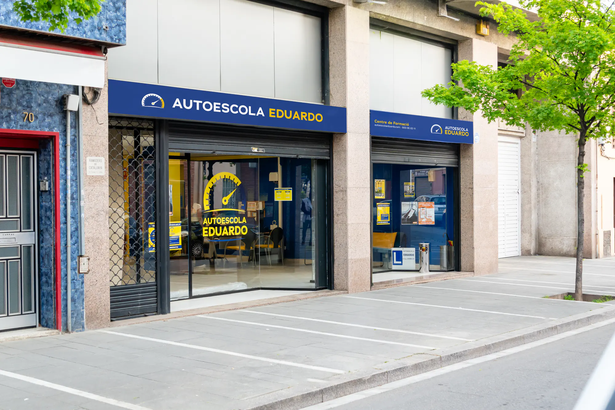 Fachada de Autoescola Eduardo con el rótulo azul y el escaparate
