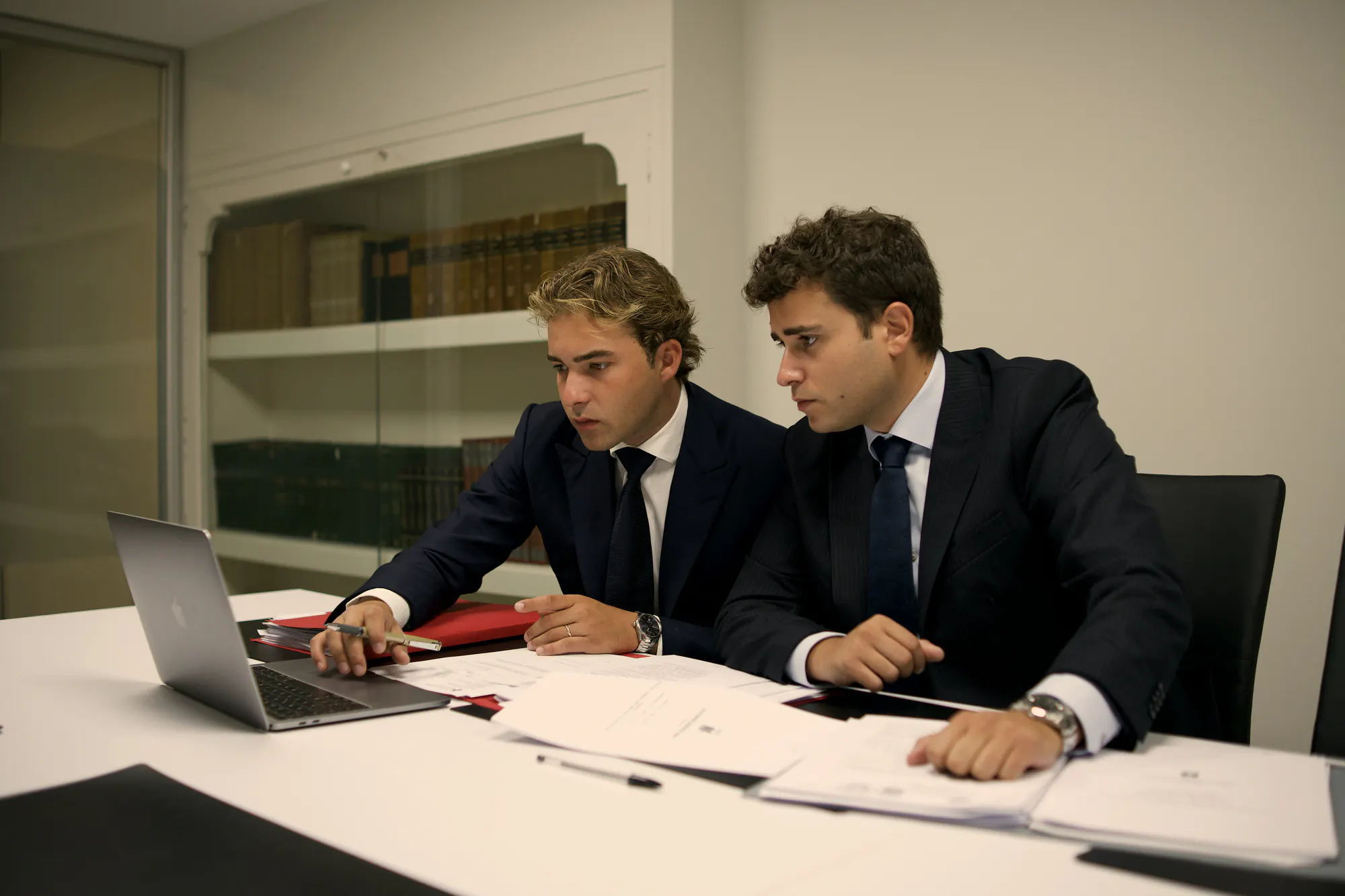 Los dos socios de Barnils & Díaz revisando un expediente en la sala de reuniones del despacho