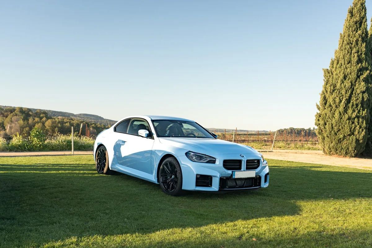 BMW M2 azul claro aparcado en el césped de unas bodegas
