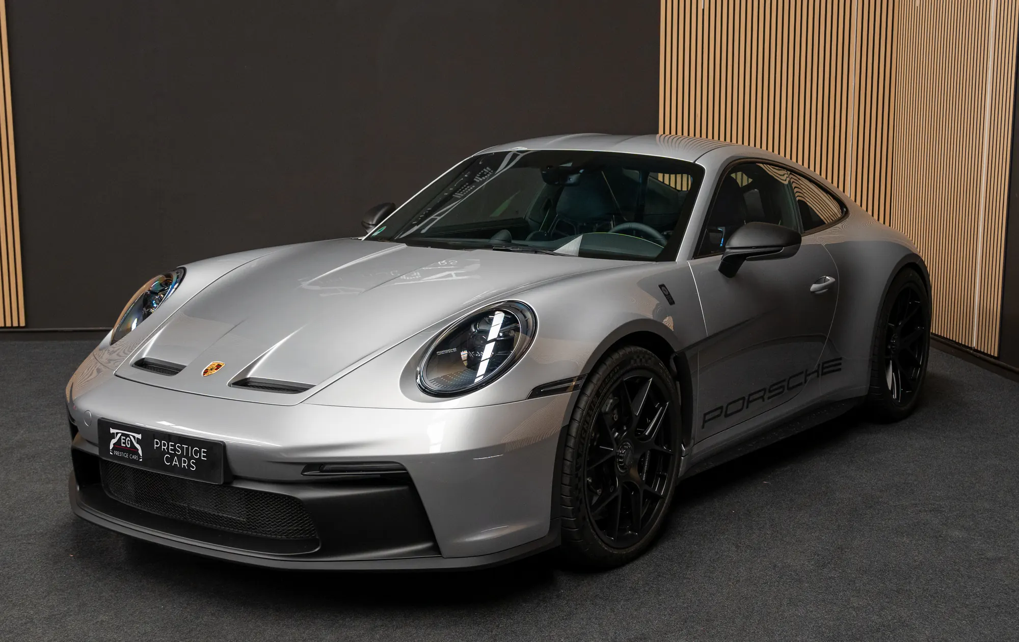 Porsche 911 S/T gris en el showroom de EG Prestige Cars, vista delantera de tres cuartos