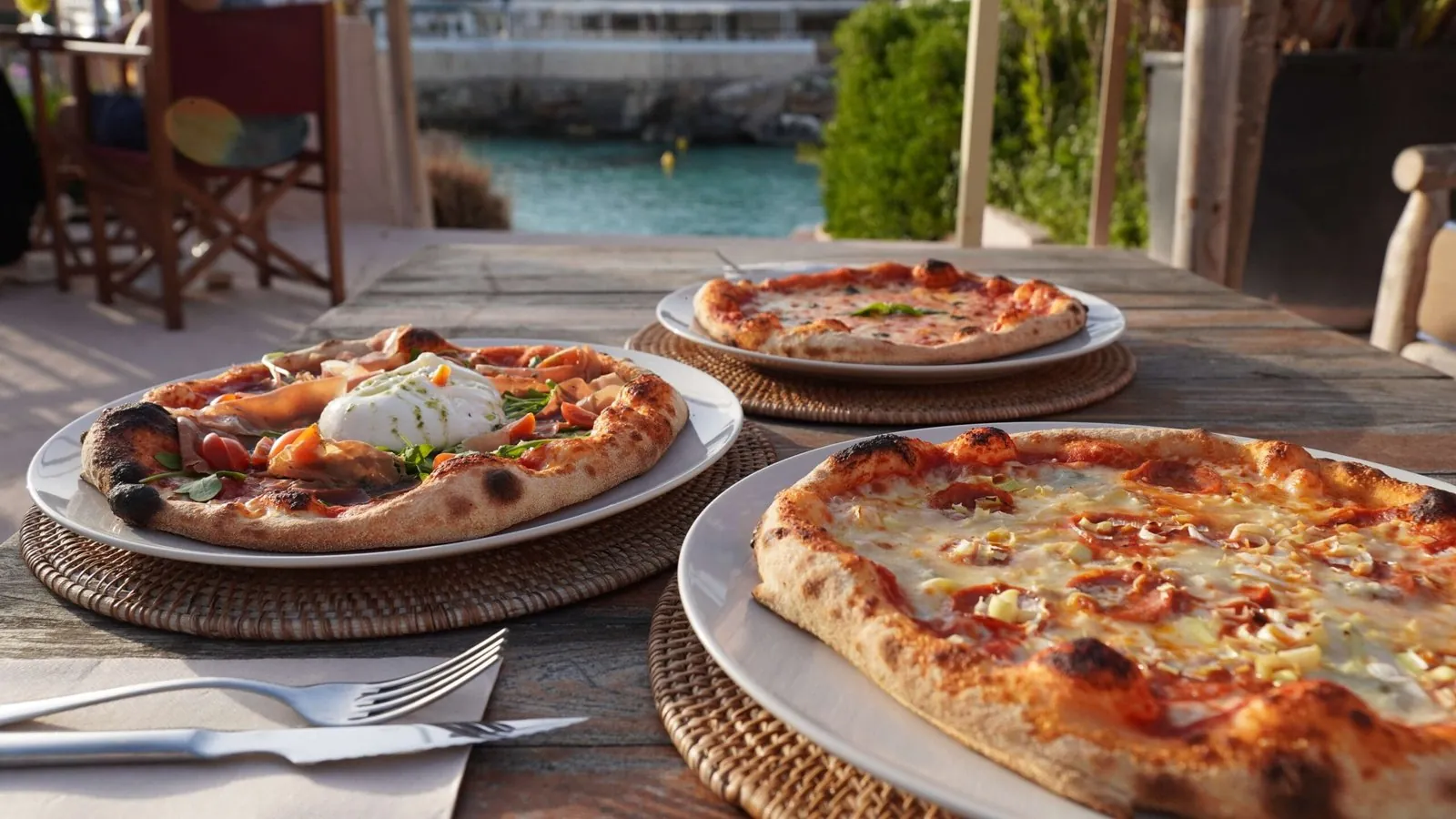 Pizzas de Forno di Marea en la terraza, con la cala de fondo