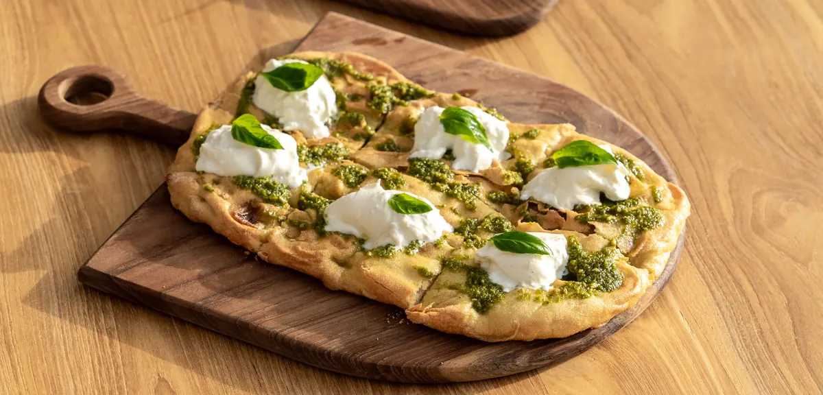 Focaccia con burrata y pesto de Forno di Marea sobre tabla de madera