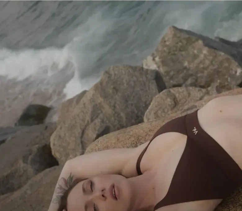 Modelo tumbada sobre las rocas en la campaña del Drop 001 de VOID dpt.